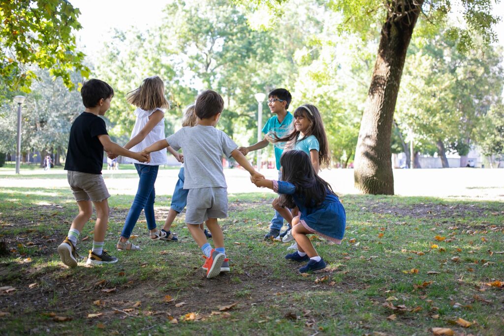 happy-children-playing-together-outdoors-dancing-around-grass-enjoying-outdoor-activities